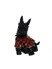 Black Scottie dog figurine with a red jacket on a white background